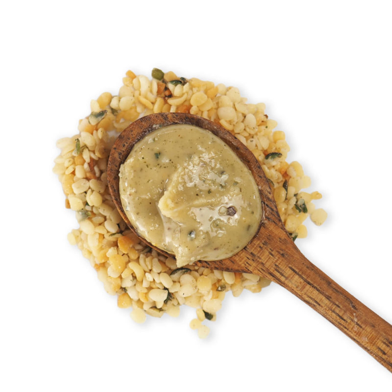Hemp puree premium, the nut puree alternative, on spoon with hemp seeds in the background